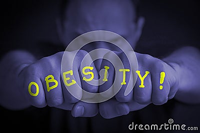 OBESITY written on an angry manâ€™s fists Stock Photo